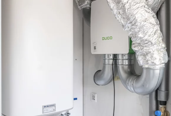 Warmtepomp van Itho Daalderop en DUCO WTW-unit in een kleine ruimte.
